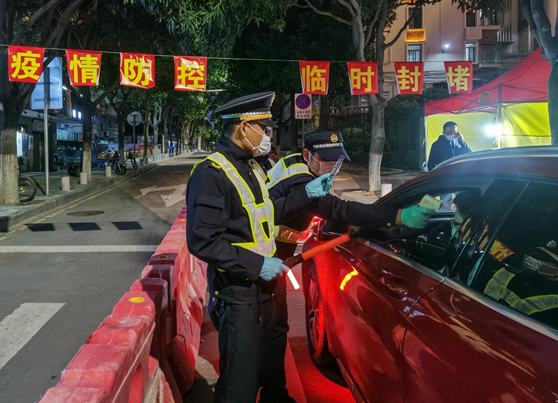 守住疫情防控的第一道防線。圖為，集美街道轄區各路口實行24小時設點檢測，夜間工作人員對駕駛員測量體溫（林志杰攝影）-181737.jpg